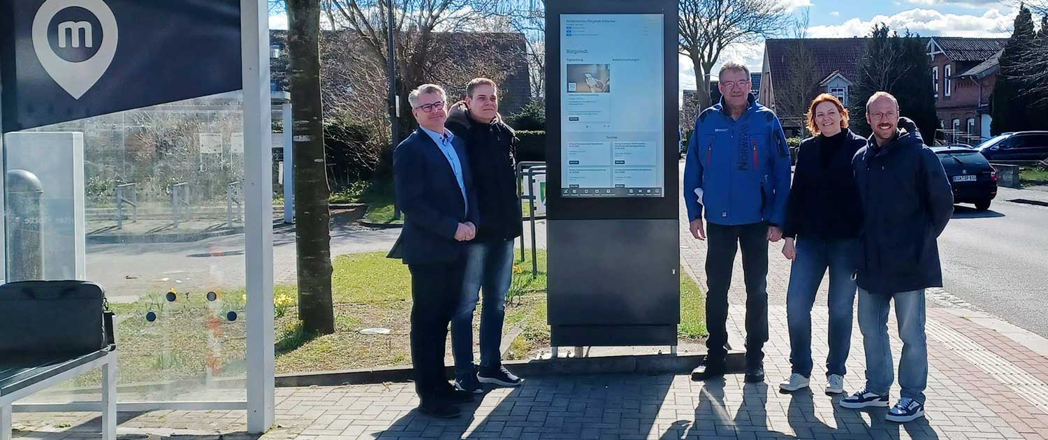 Gruppenbild vor dem Digitalen Informationskasten der Gemeinde Borgstedt